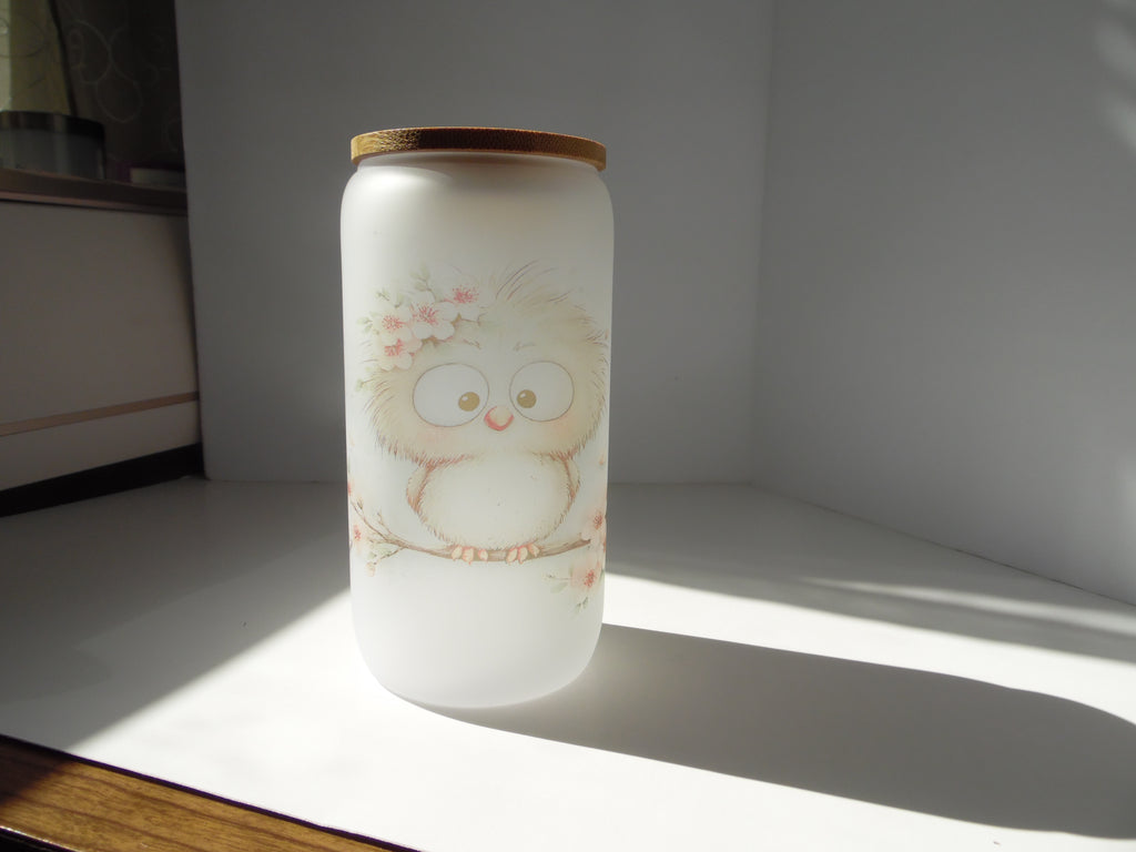 Original photo of frosted glass cup with a fluffy cream owl and pink blossoms