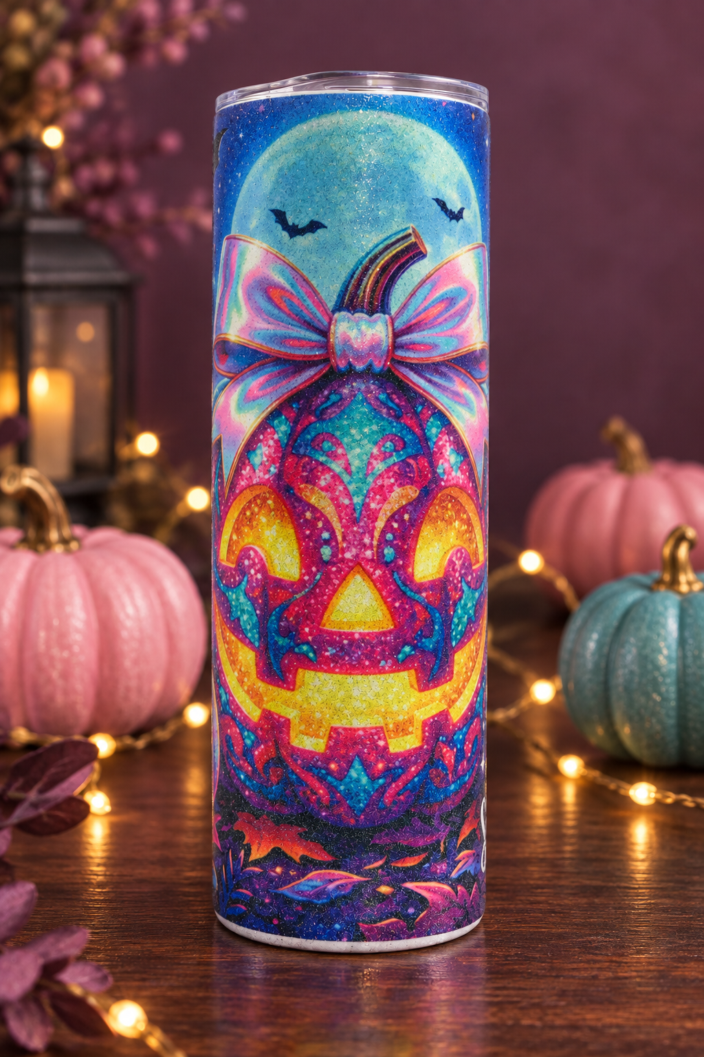 Pink pumpkin and bow glitter tumbler in a cozy Halloween setting